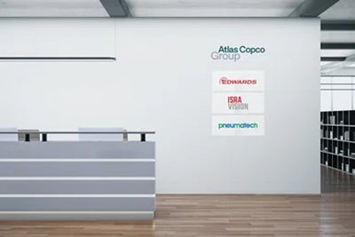 Reception area branding with the Atlas Copco Group logotype and other brands below.