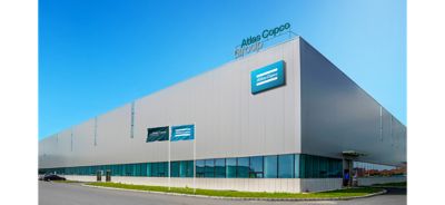 Facility branding showing the Atlas Copco Group logo at the top of the building, and the Atlas Copco logo below on a sign on the exterior itself.