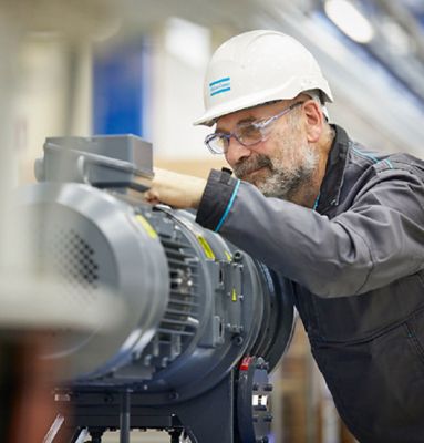 An Atlas Copco employee working with an industrial tool