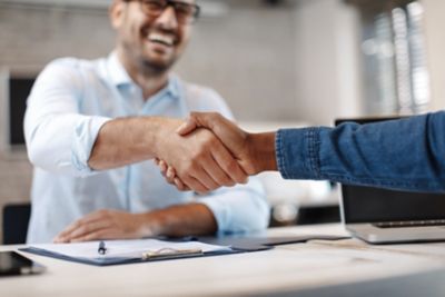 Two people shaking hands in a business environment.