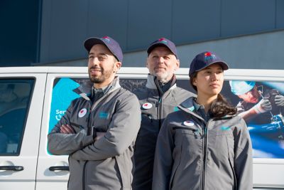 Group of 3 service technicians in front of a service van, male and female