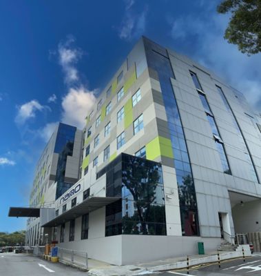 A modern-looking office building with a nano-purification solutions sign on the front, to show our Singapore location