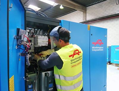 Installation d'un compresseur à vis par un technicien.