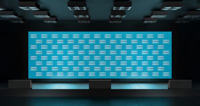 A static Atlas Copco backdrop on the stage of an event facility