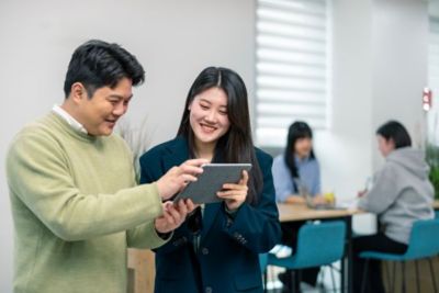 Two employees watching something on a shared tablet