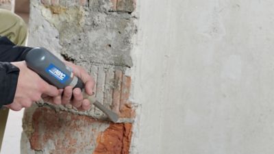 Air compressor and pneumatic chisel tool in action in construction