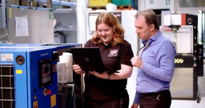 Service engineer bekijkt op laptoo samen met klant