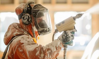 Worker spraying foam insulation in a homes for references