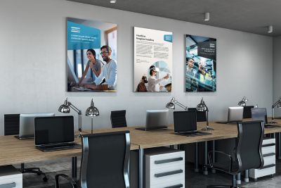 An office workstation environment with Atlas Copco imagery decorating the walls.