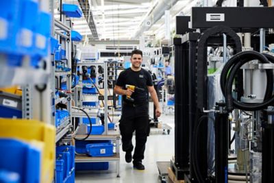 Employee in the innovation center walking with a drill in his hand