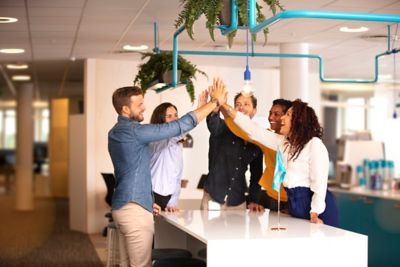 Employees doing a high-five in the office.