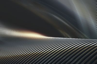 Tightly woven carbon fiber or metallic textile pattern, with a crisscross effect. The layered texture shifts under a soft directional light, emphasizing durability and technical precision.