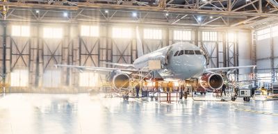 Airplane mechanic working in aviation hangar.