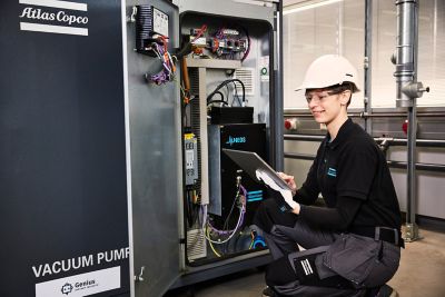 A woman engineer checking an equipment with a tablet in hand.