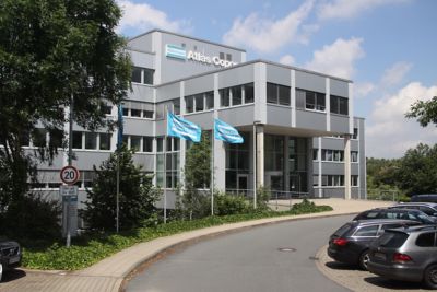 Atlas Copco Hauptzentrale in Deutschland in Essen – modernes Bürogebäude mit Unternehmensflaggen. Als Symbol für Innovation und Technologie​.