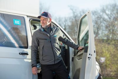 Technik serwisowy wysiadający z furgonetki serwisowej