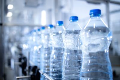 Close up view of bottles of water in bottling factory being transported by conveyor belt