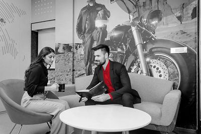 Woman and man in office lounge area.