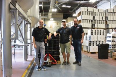 A picture of a nano sales representative, distribution representative, and customer at an installation at Coppertail Brewing