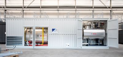 A custom-made container housing a Bosch industrial boiler system, with Eco branding, open doors revealing piping, and a clean industrial setting in the background.