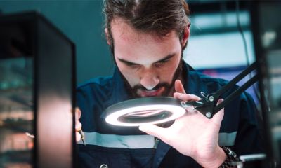 Technician looking closely at something under a light.