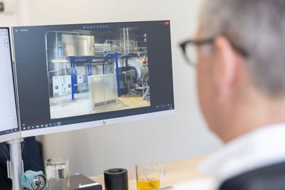 Close-up of a project engineer reviewing a steam solution design on a monitor, showing an industrial steam boiler system.