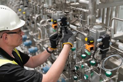 A service engineer checks a pneumatic valve in oil and gas industry.