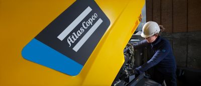 Woman in hardhat working on one of our machines. ​
