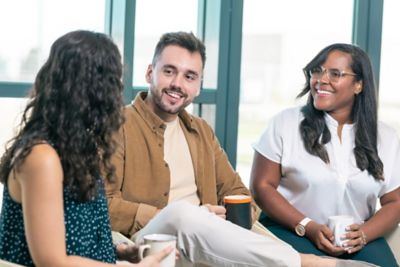 Close-up of employees in discussion over coffee