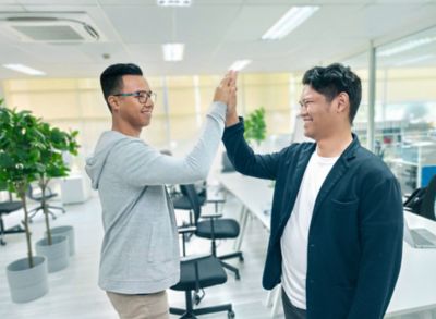 Employees giving each other a high five in the office