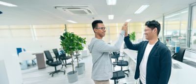 Employees giving each other a high five in the office