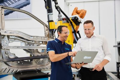 Employees discussing in front of a piece of equipment in the innovation center