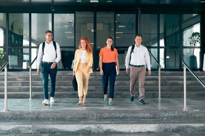 Employees posing looking into camera as they walk down office steps