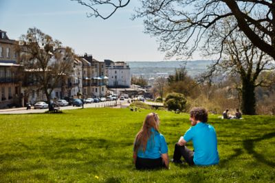 Bir kadın, bir erkek çalışan şehir içerisindeki parkta oturuyor.​