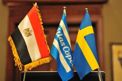 Flags of Egypt, Atlas Copco, and Sweden displayed together, symbolizing Atlas Copco's presence in Egypt and Swedish heritage​.