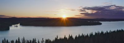 Sun setting over the forest surrounding one of many Swedish lakes. 