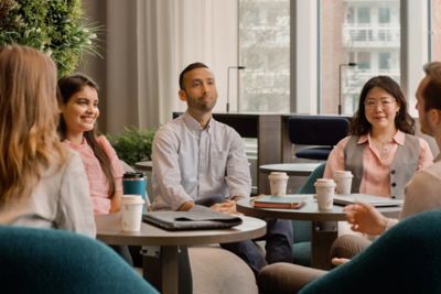 Colleagues in conversation over coffee.