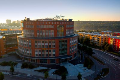 Atlas Copco Group headquarters, located in Sickla, Sweden. It is a round building with red brickwork and many windows.