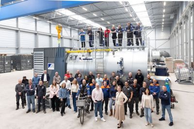 Group photo of Eco Steam and Heating Solutions team members in front of a boiler installation.
