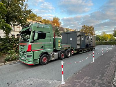 Hot water boiler on a truck. The truck is parked in a domestic district. 