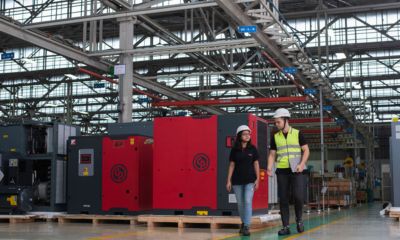 Two colleagues walking along a factory floor.
