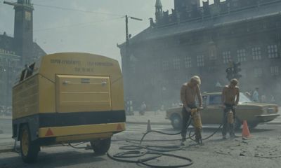 Historical image of workers near a compressor.