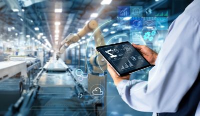 Smart industry control concept.Hands holding tablet on blurred automation machine as background