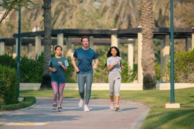 People in sporting gear jogging down a track