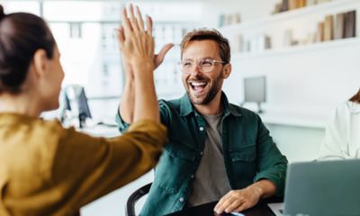 Two colleagues high fiving each other.