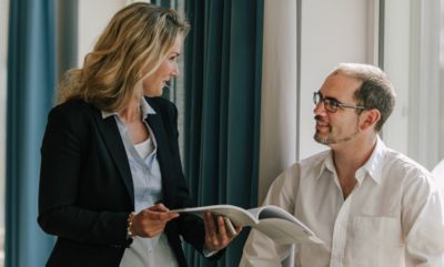 Employees discussing a brochure. 