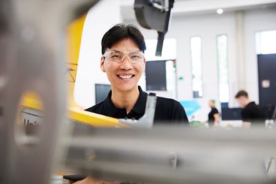 Employees posing for camera behind equipment