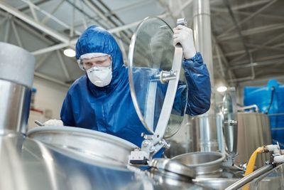 A chemical manufacturing worker opens a chemical tank to observe nitrogen gas blanketing