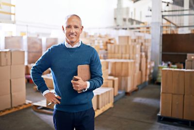 A man holds a clipboard in a warehouse