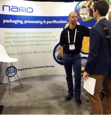Mark in front of the nano booth at a tradeshow.